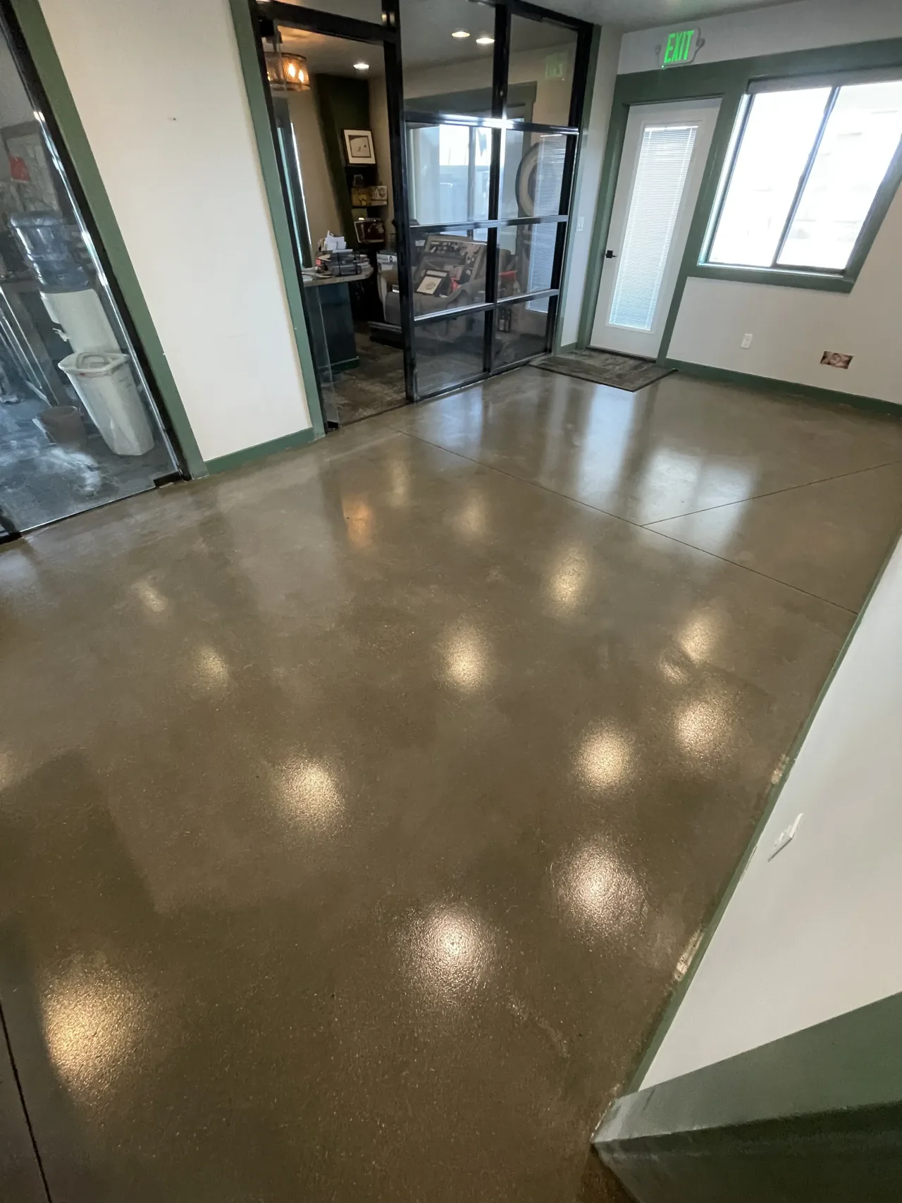 Brown-toned concrete floor beside a glass-walled entrance