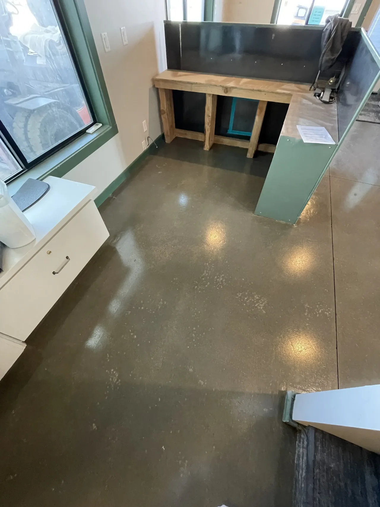 Brown-toned interior concrete floor with a work table by the window