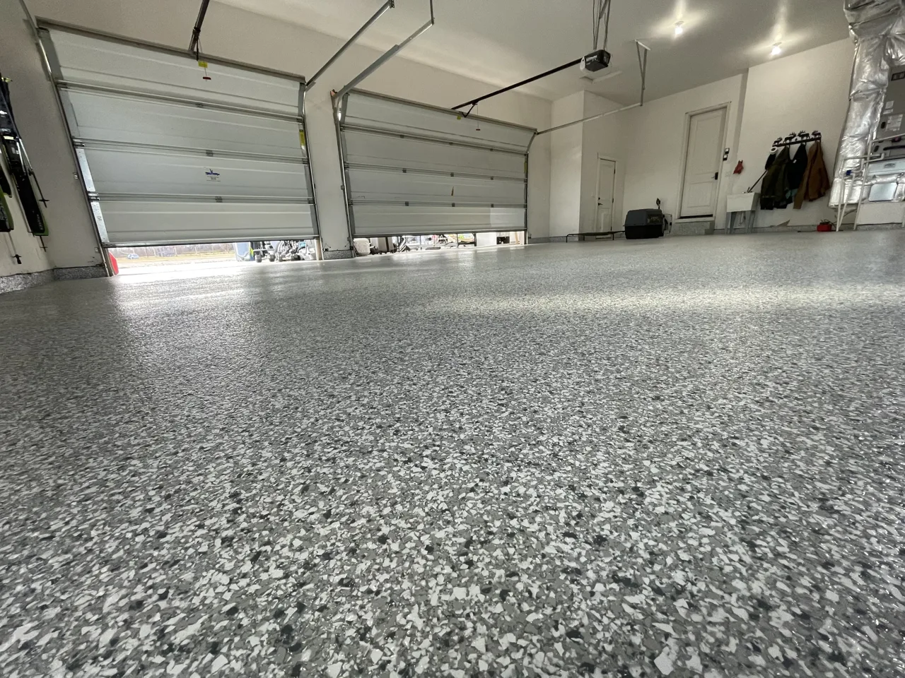 Close view of gray flake garage flooring and overhead doors