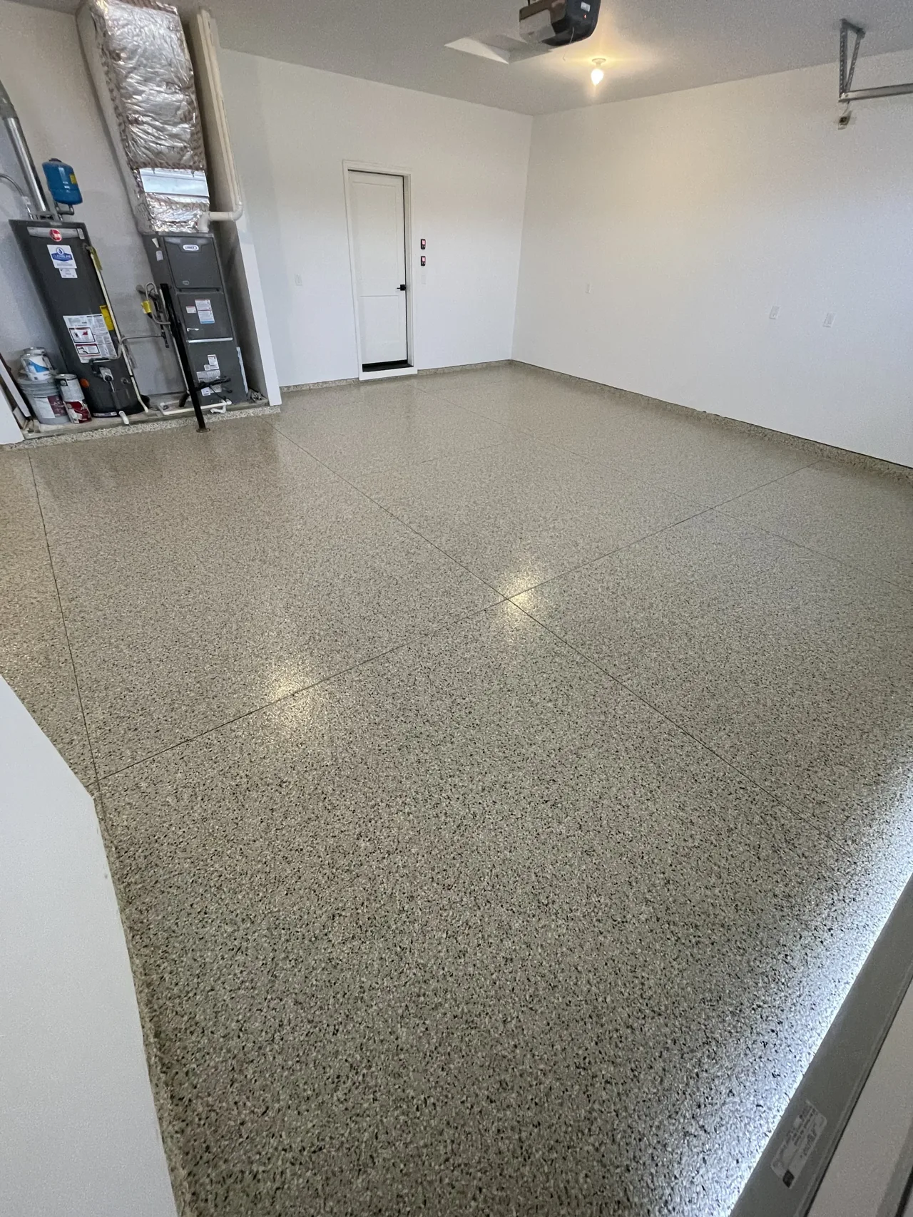 Gray flake garage floor viewed toward a white entry door
