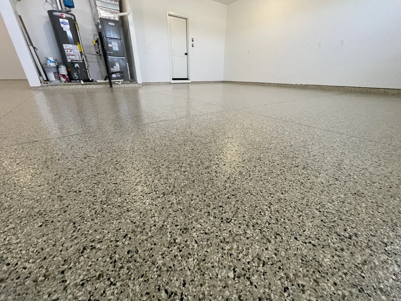 Gray flake garage floor beside a white entry door