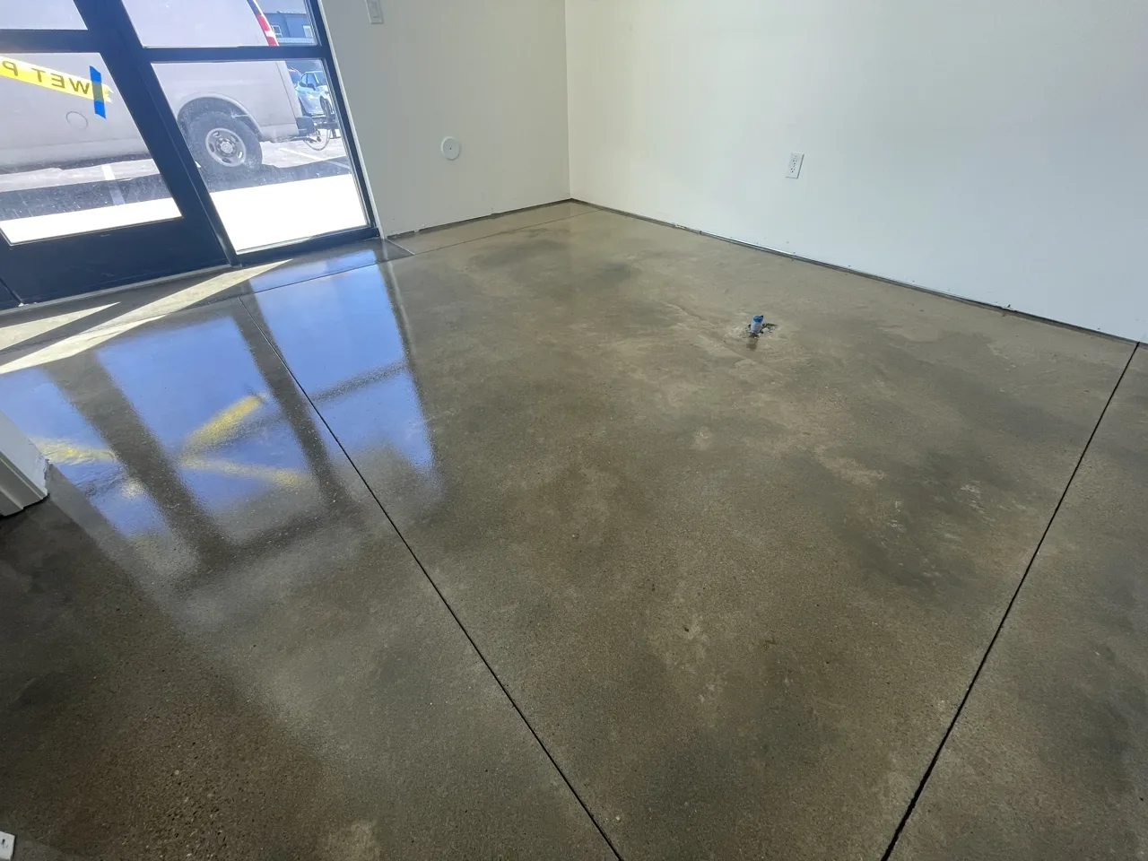 Mottled concrete floor viewed toward glass entrance doors