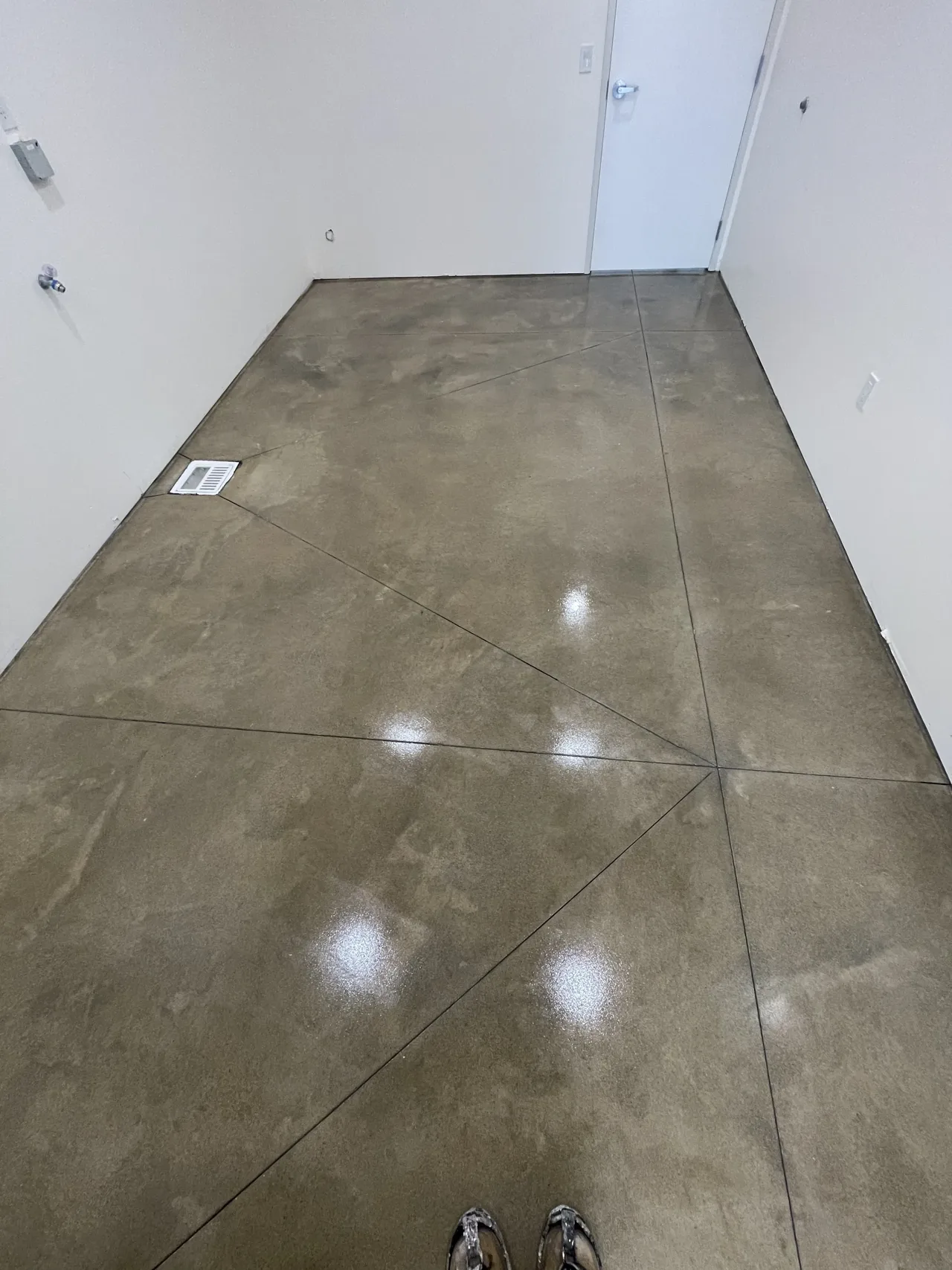 Brown-toned concrete floor in a narrow interior room