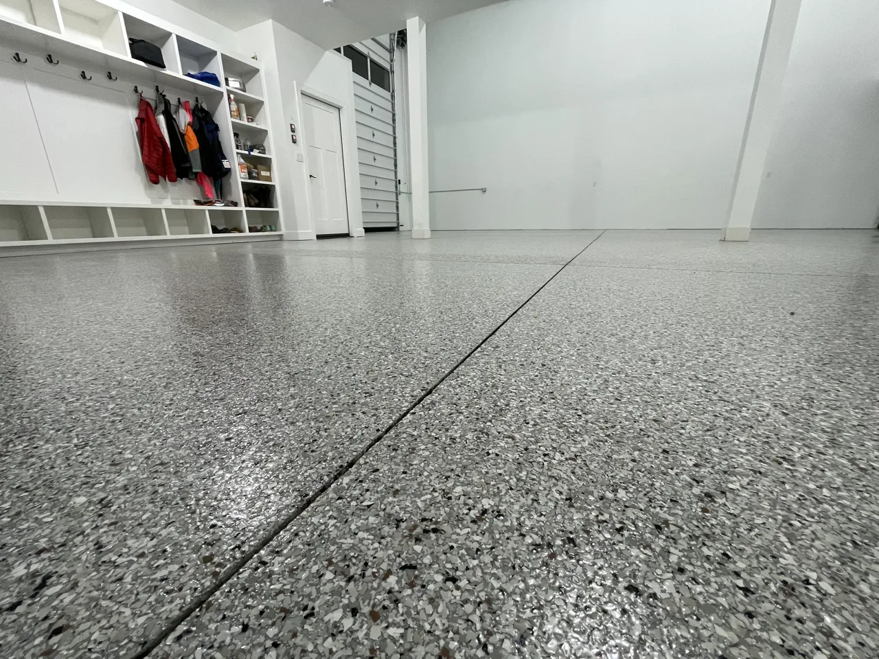 Gray flake garage floor viewed toward wall shelving