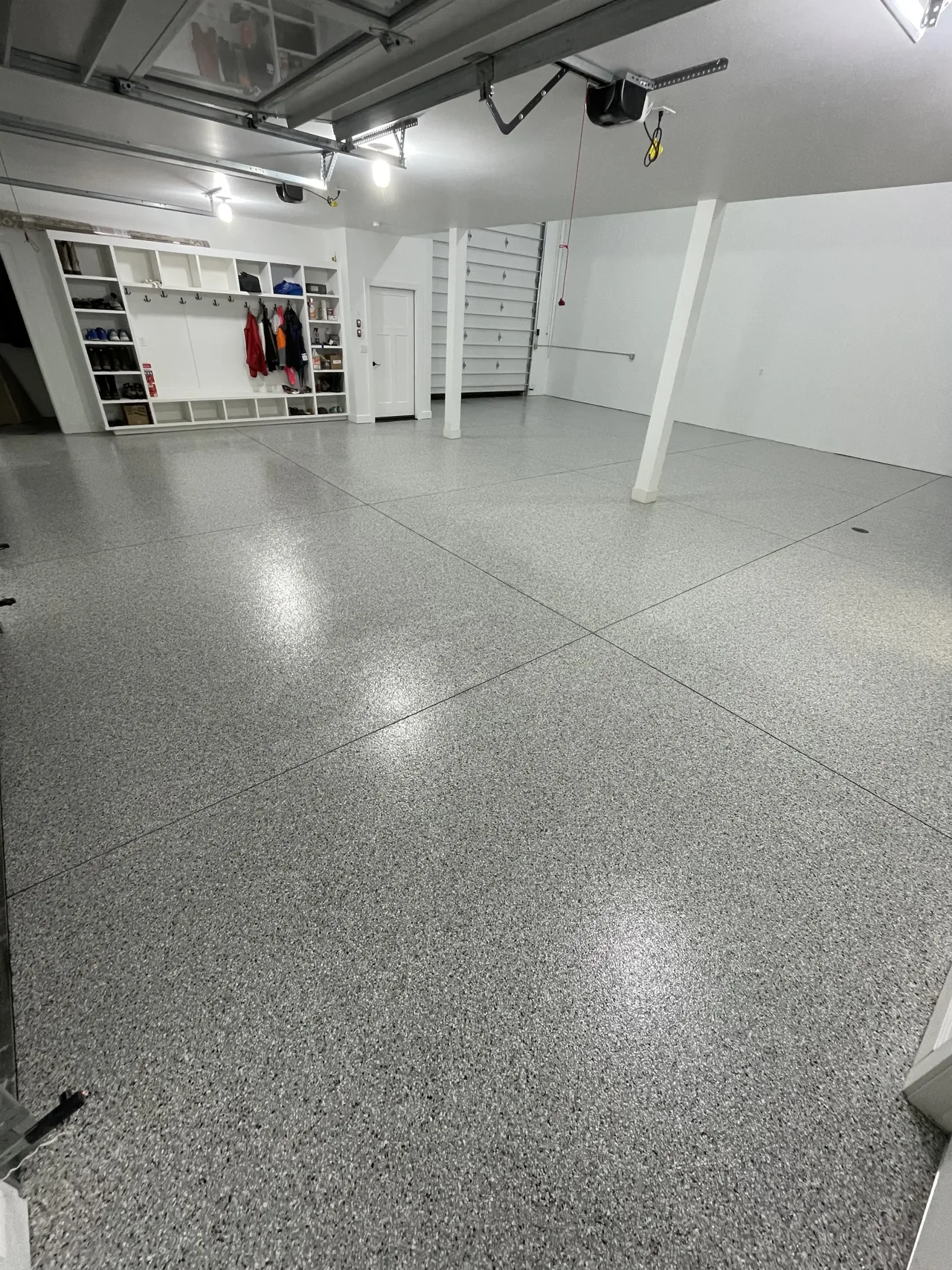Gray flake garage floor with black posts and exposed ductwork