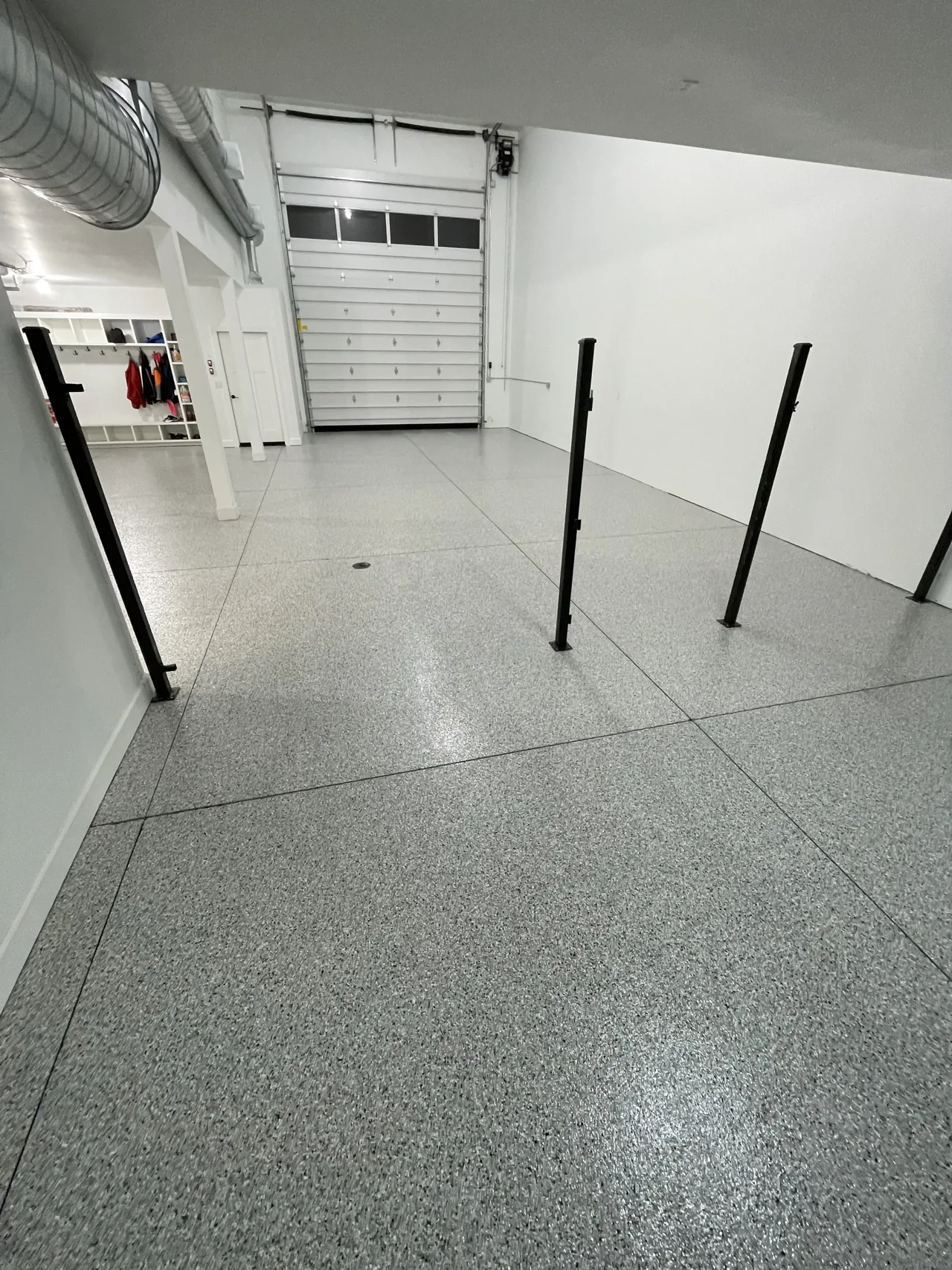 Gray flake floor in a garage with exposed ceiling ducts