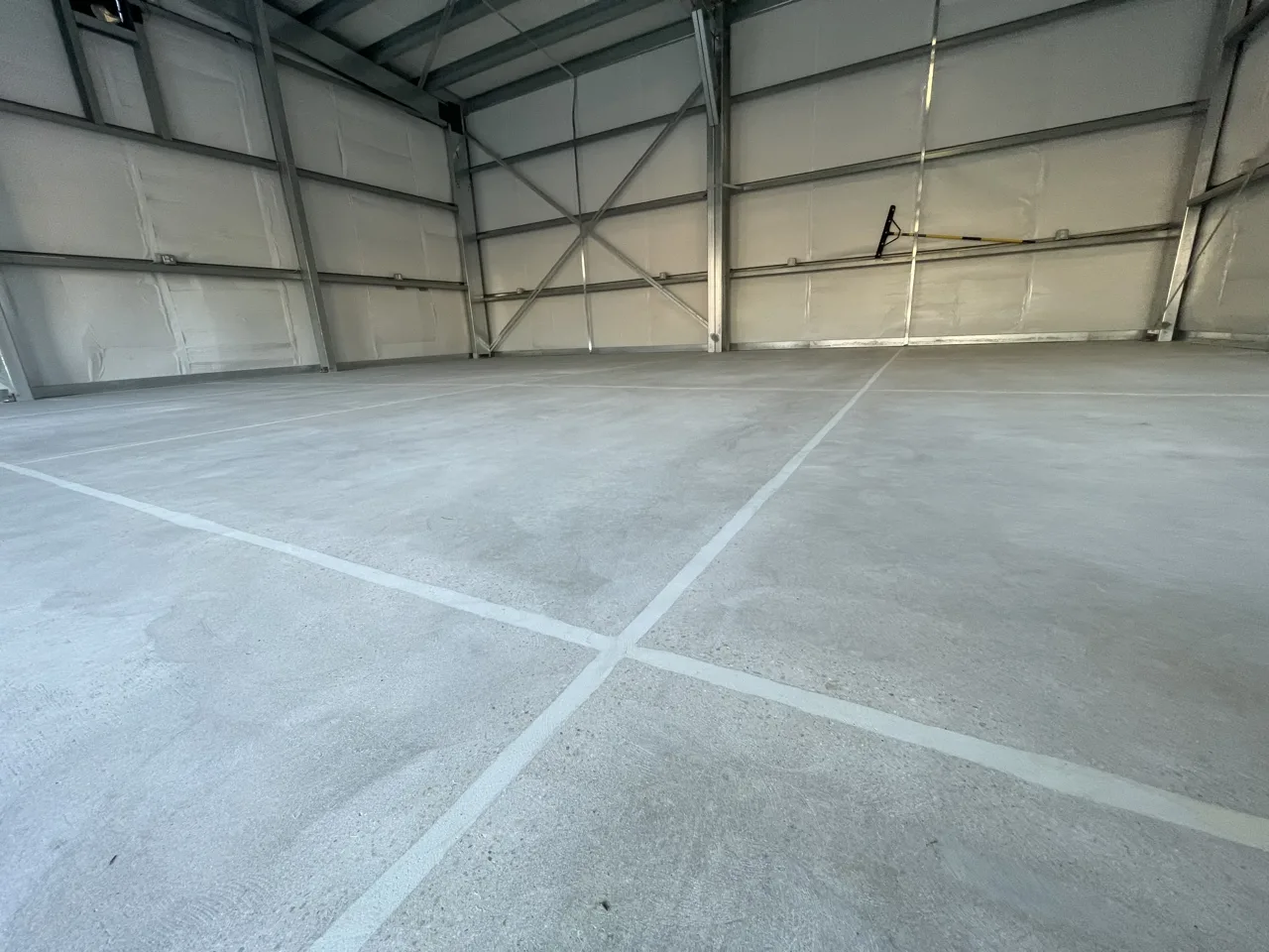 Uncoated concrete slab with visible joint detail in a metal-framed shop