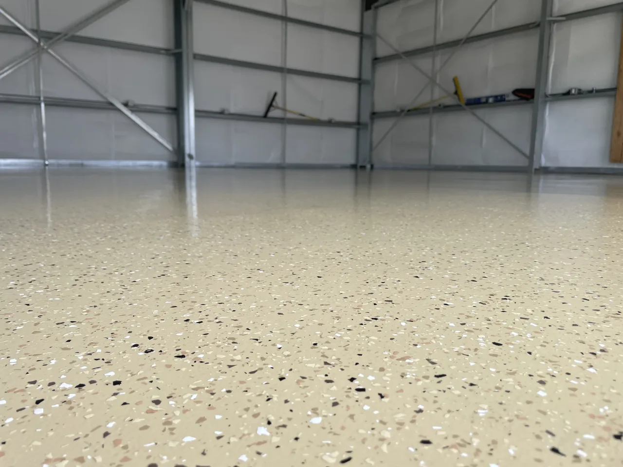 Tan flake floor across a metal-framed shop