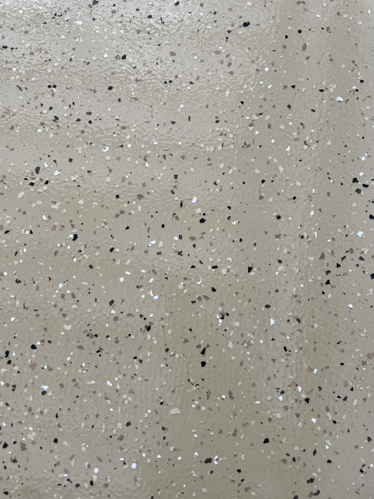 Close view of tan decorative flake flooring